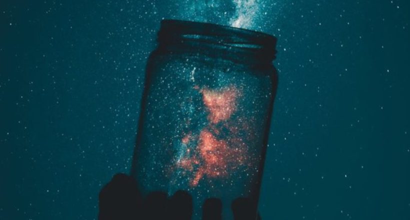 silhouette of person holding glass mason jar