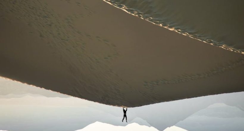 photo of man doing handstand on desert