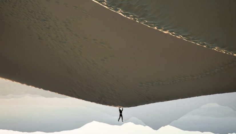 photo of man doing handstand on desert