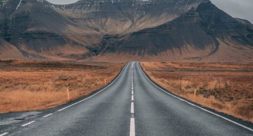 empty highway overlooking mountain under dark skies