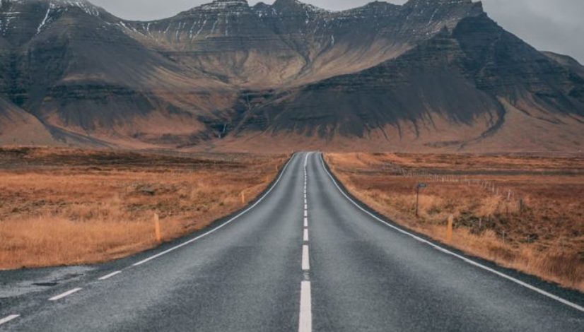 empty highway overlooking mountain under dark skies