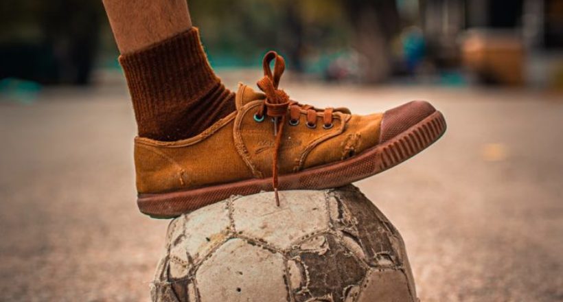 person stepping on a soccer ball