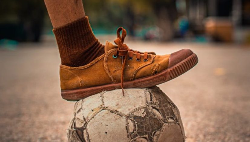 person stepping on a soccer ball